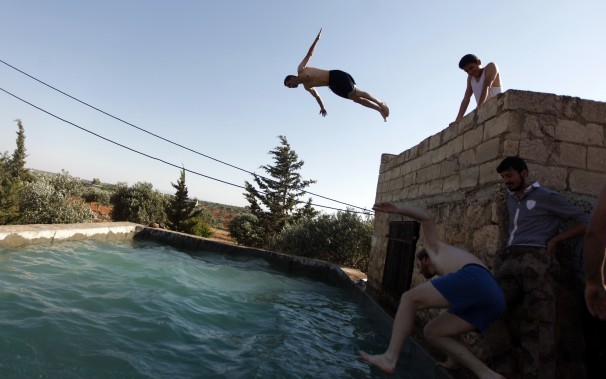 Hình ảnh binh lính thỏa thích vui đùa tại một bể bơi ở ngoại ô Aleppo.